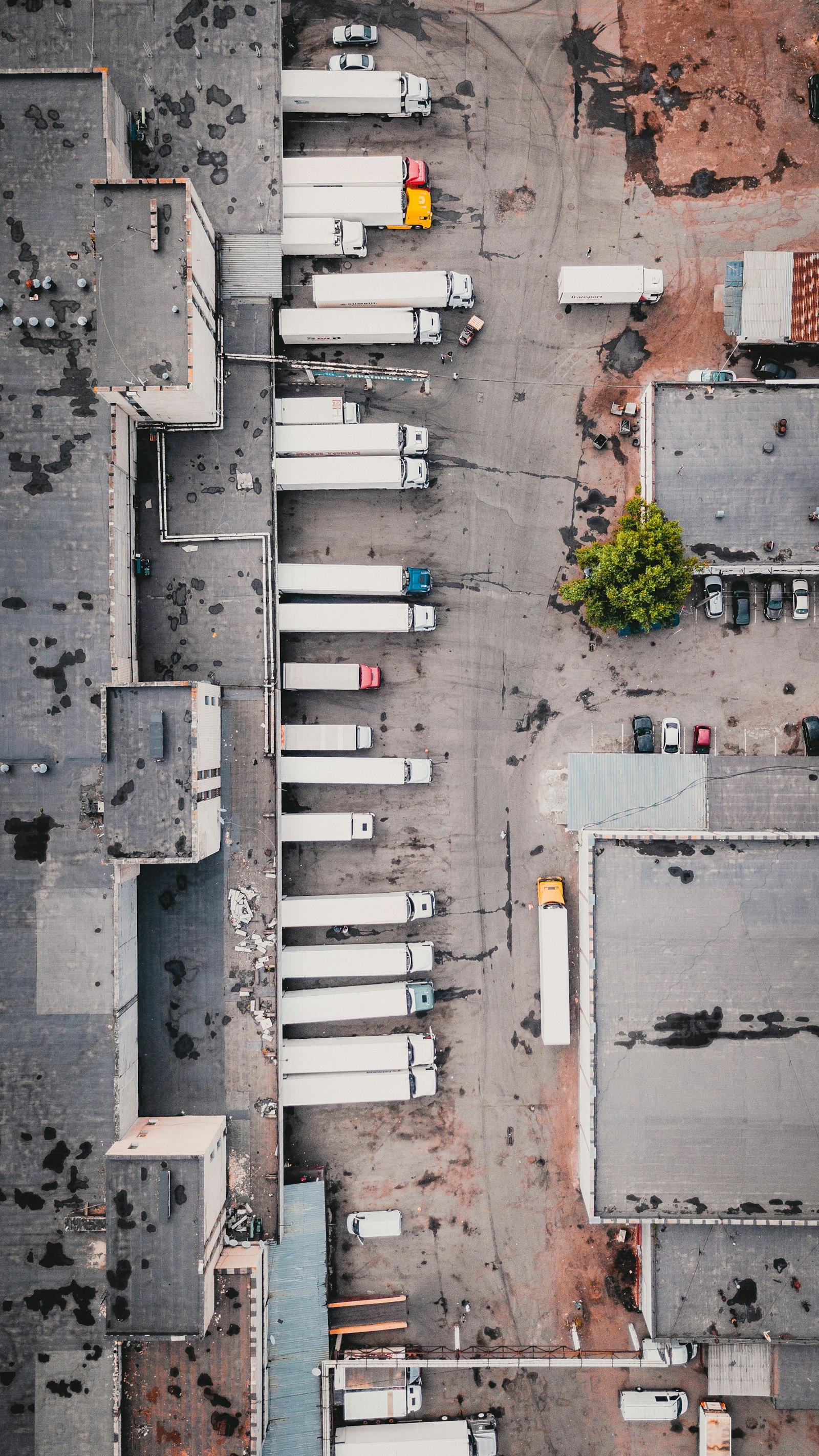 Aerial view of semi trucks lined up at a logistics yard